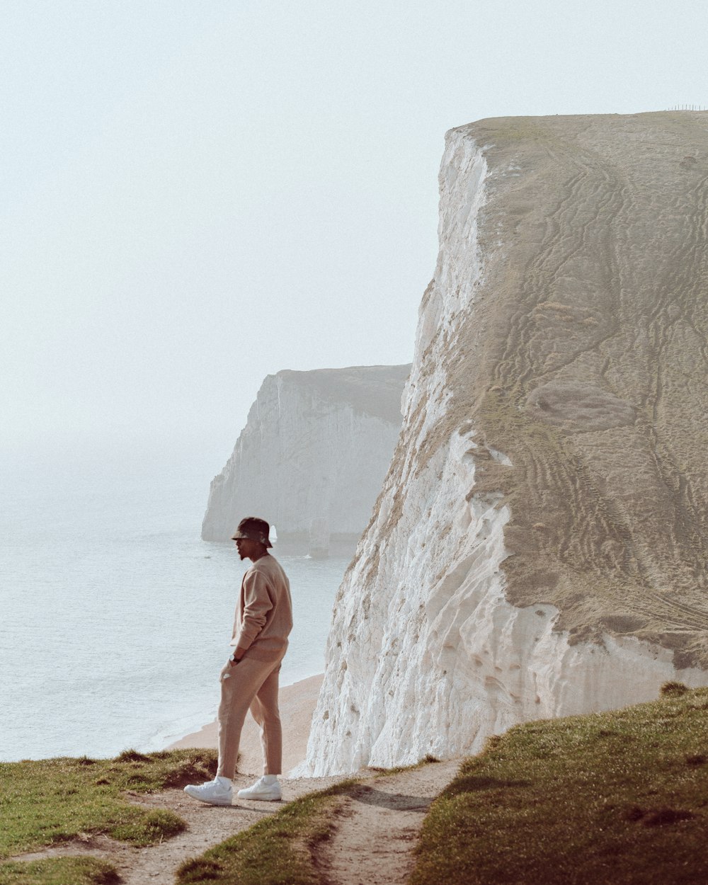 a man standing at the edge of a cliff overlooking the ocean