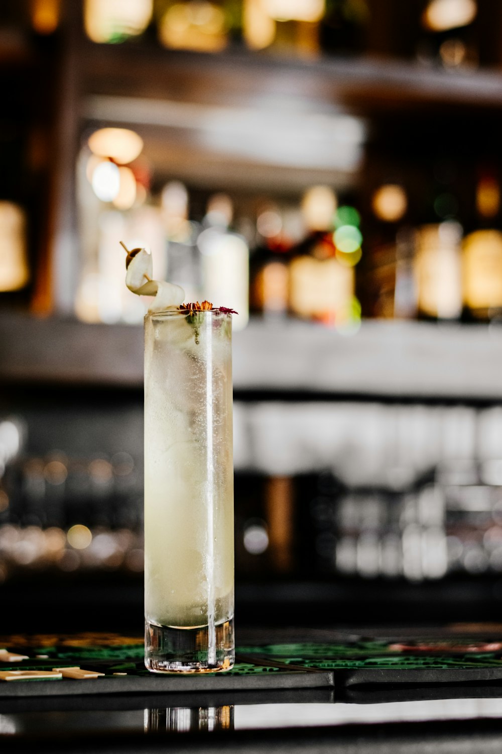 a tall glass filled with a drink sitting on top of a table