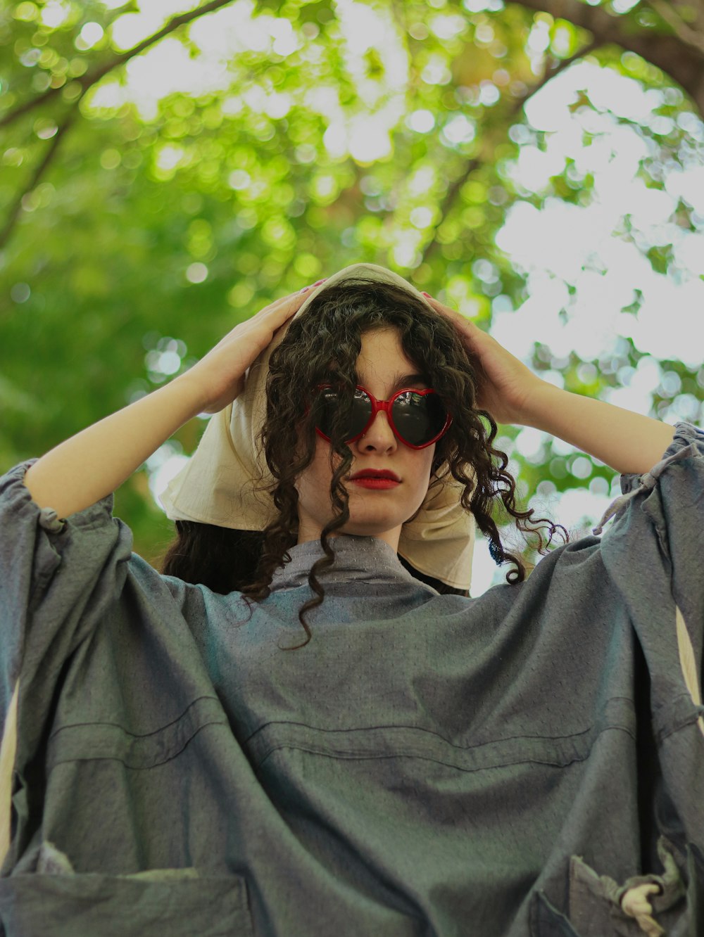 a woman with curly hair and sunglasses covering her face