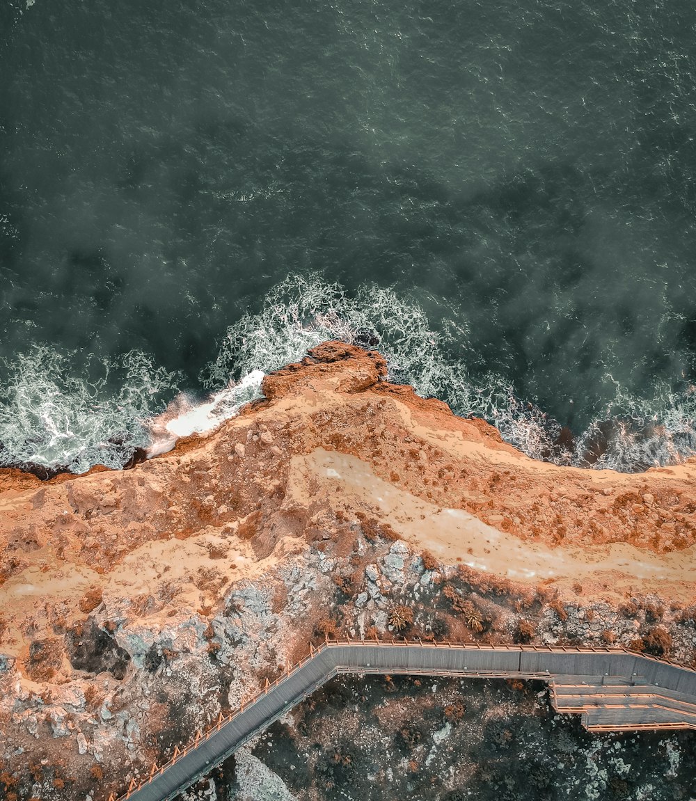 an aerial view of the ocean with waves crashing on the shore