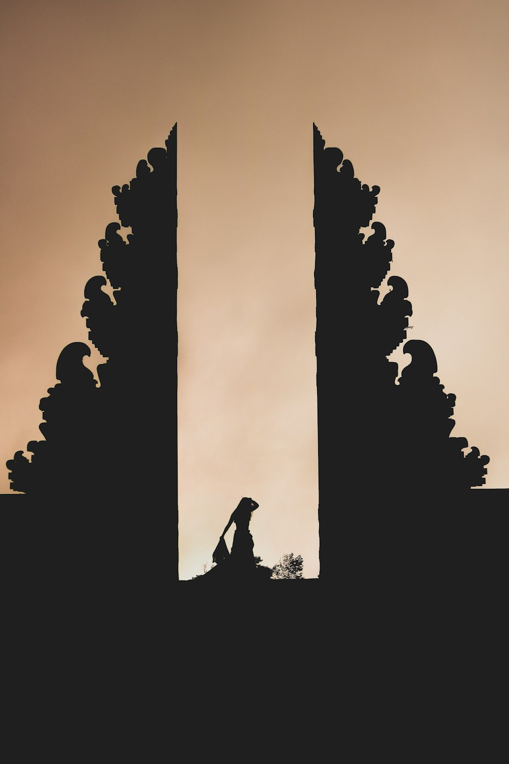 a silhouette of a person sitting on top of a building