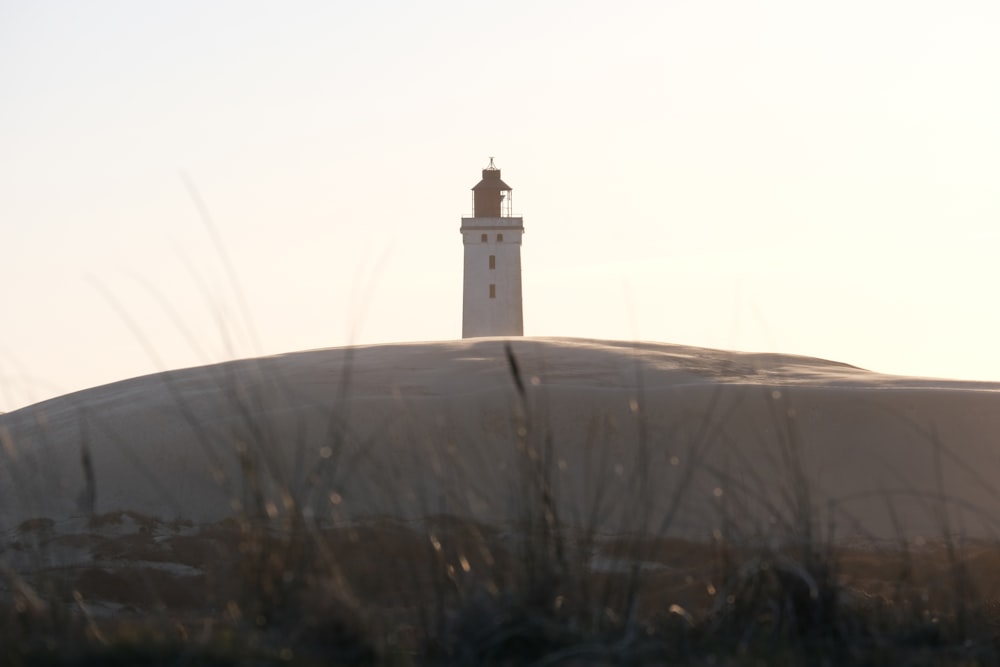 a white lighthouse on top of a hill