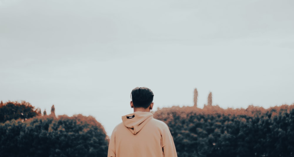 a man standing in front of a hedge