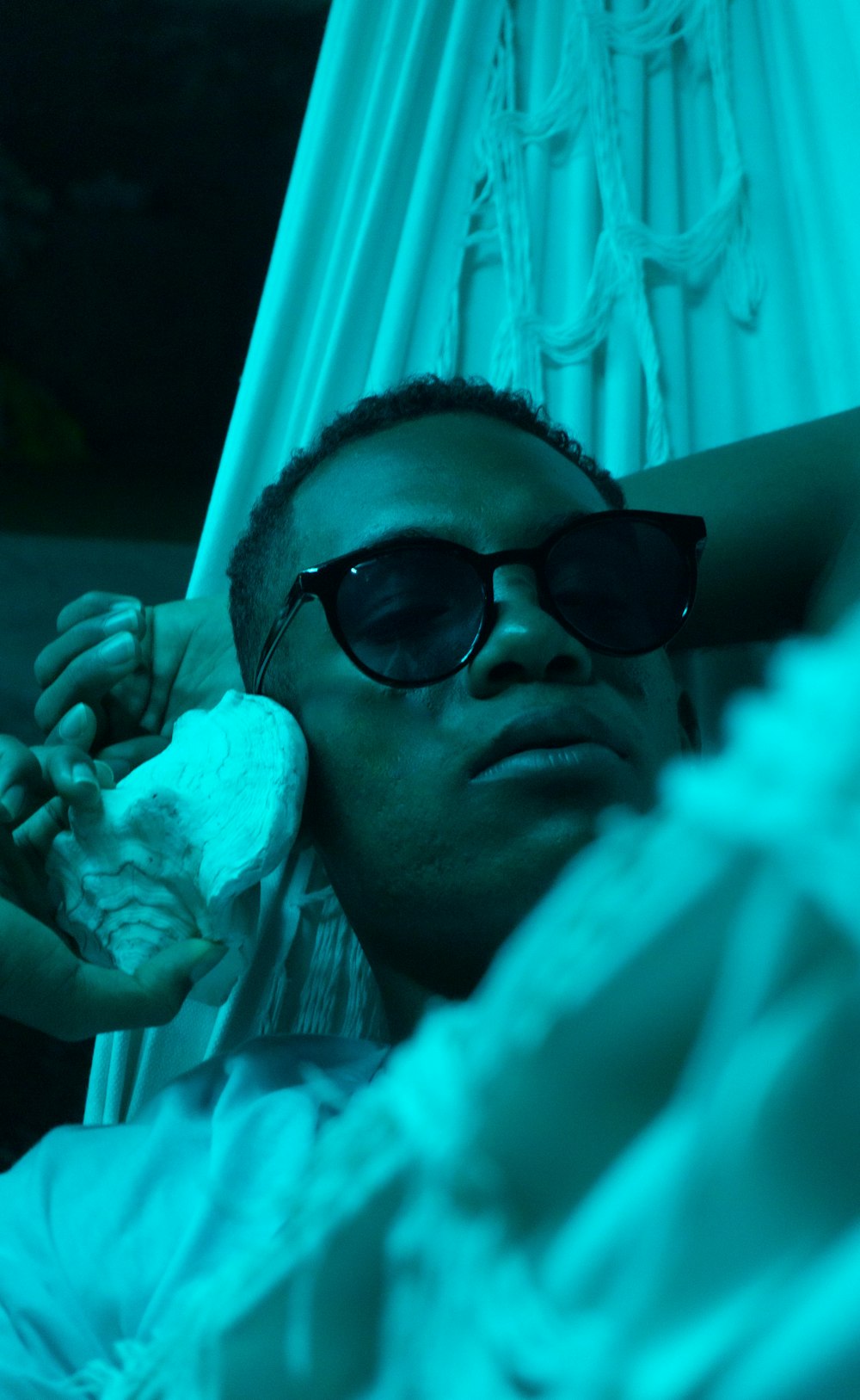 a man in sunglasses laying in a hammock