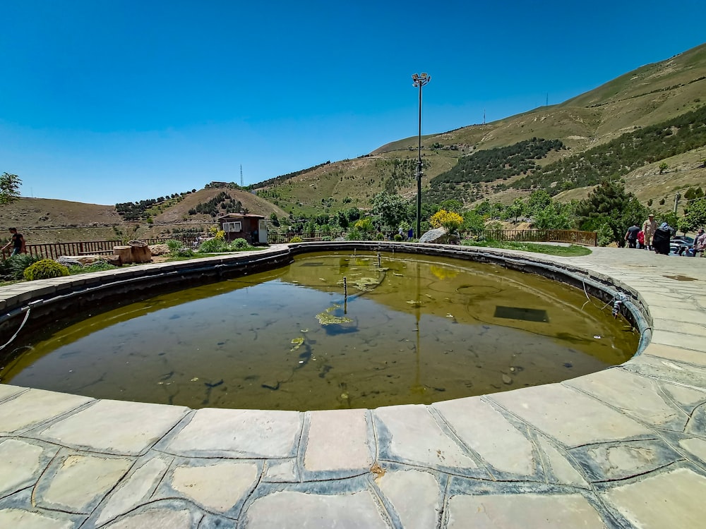 a small pond in the middle of a stone walkway