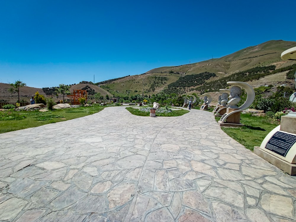 a stone walkway with sculptures on each side of it