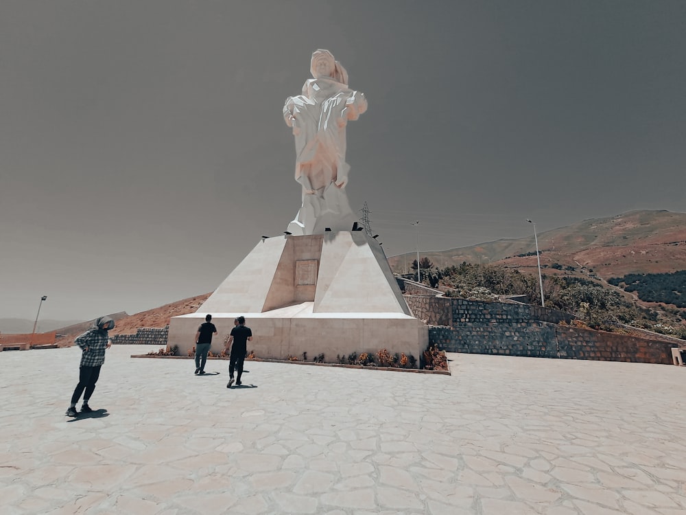 a group of people standing around a statue