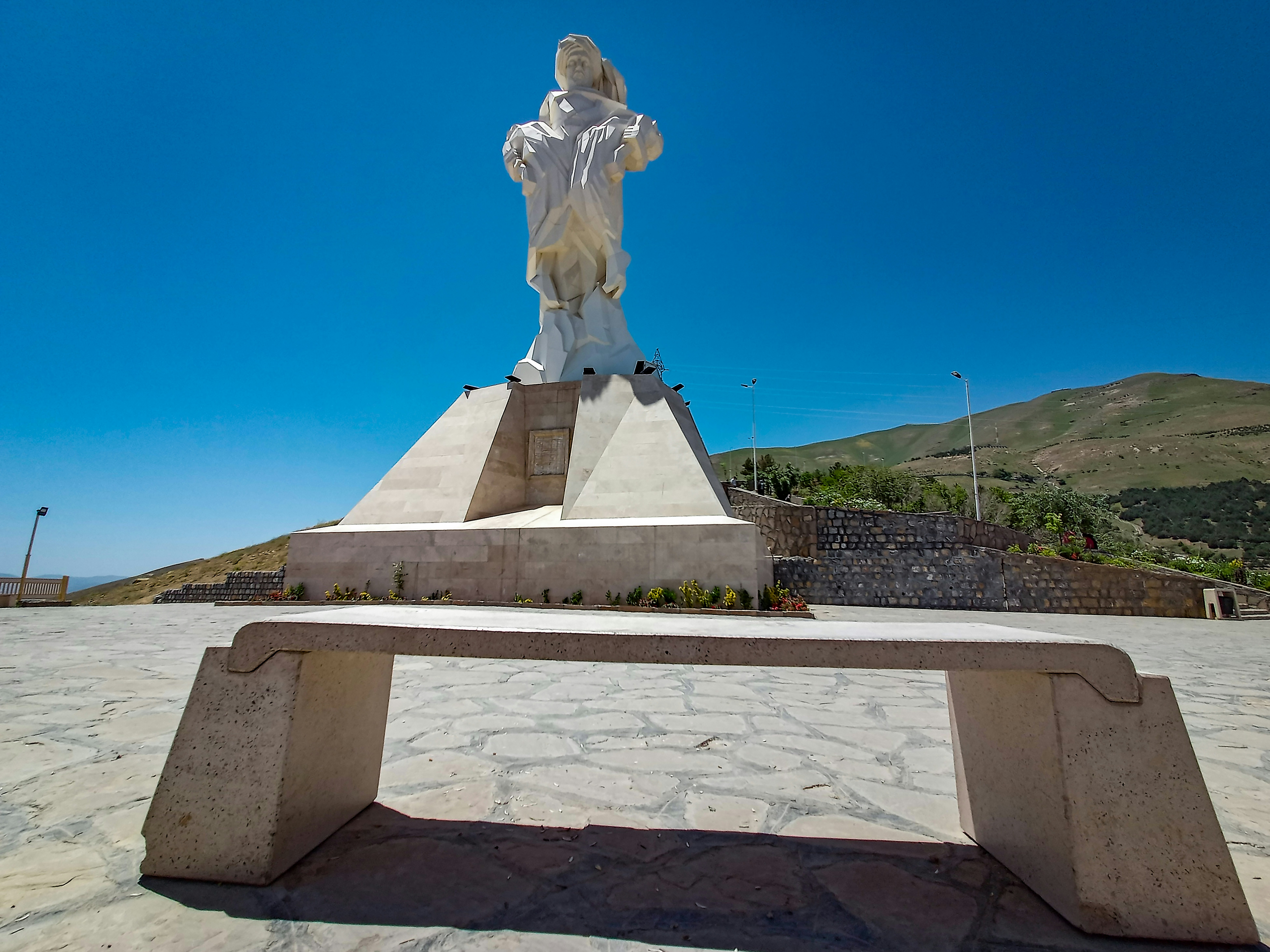 a statue of a woman sitting on top of a bench