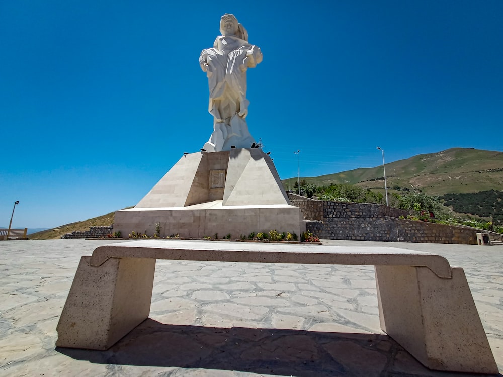 a statue of a woman sitting on top of a bench