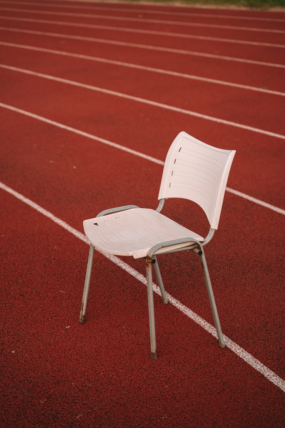 a white chair sitting on top of a red track