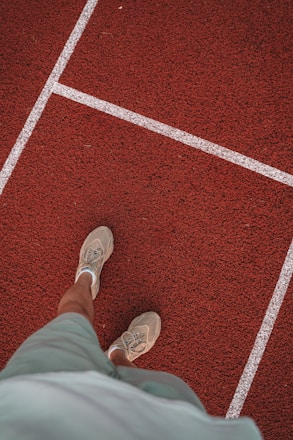 A coach analyzing a young athlete's running form on a track during training.