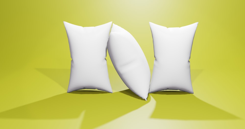 a pair of white pillows sitting on top of a green floor