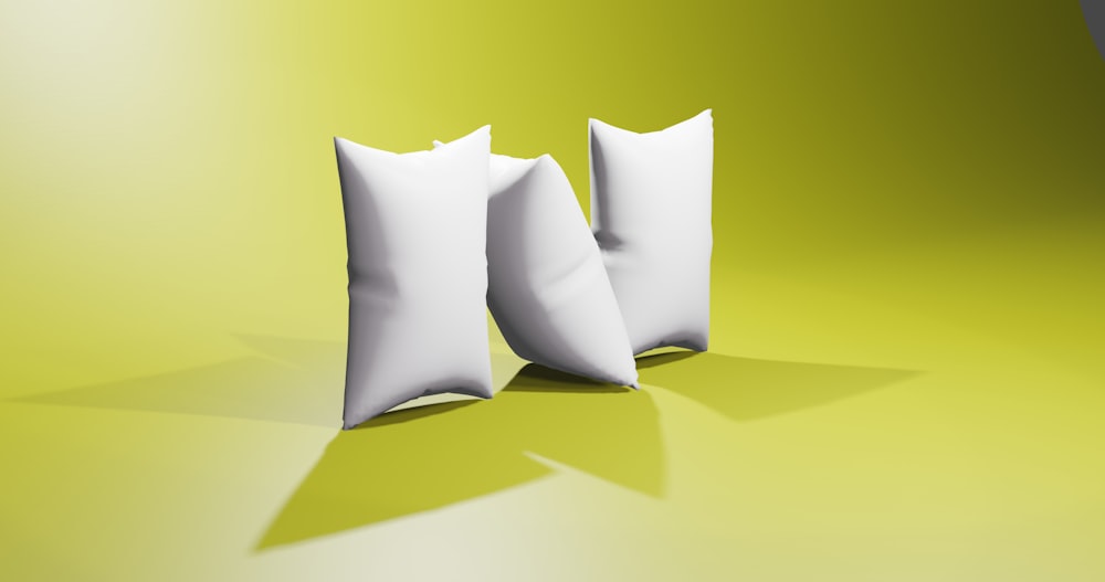 two white pillows sitting next to each other on a green surface