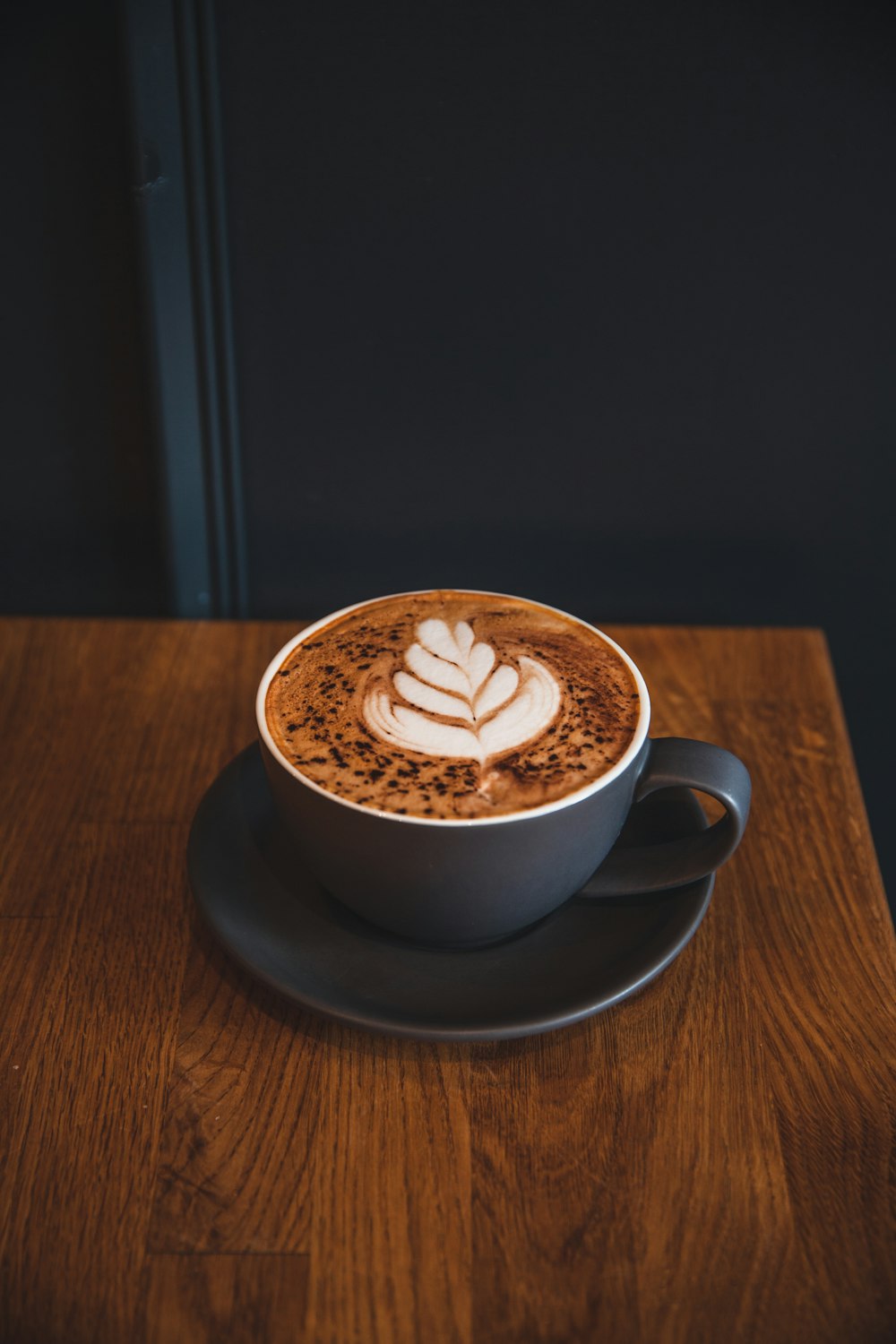 a cup of cappuccino on a wooden table