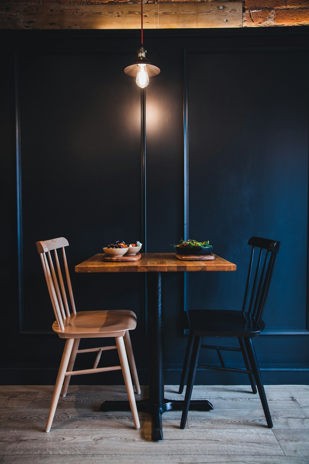 a wooden table with two chairs next to it