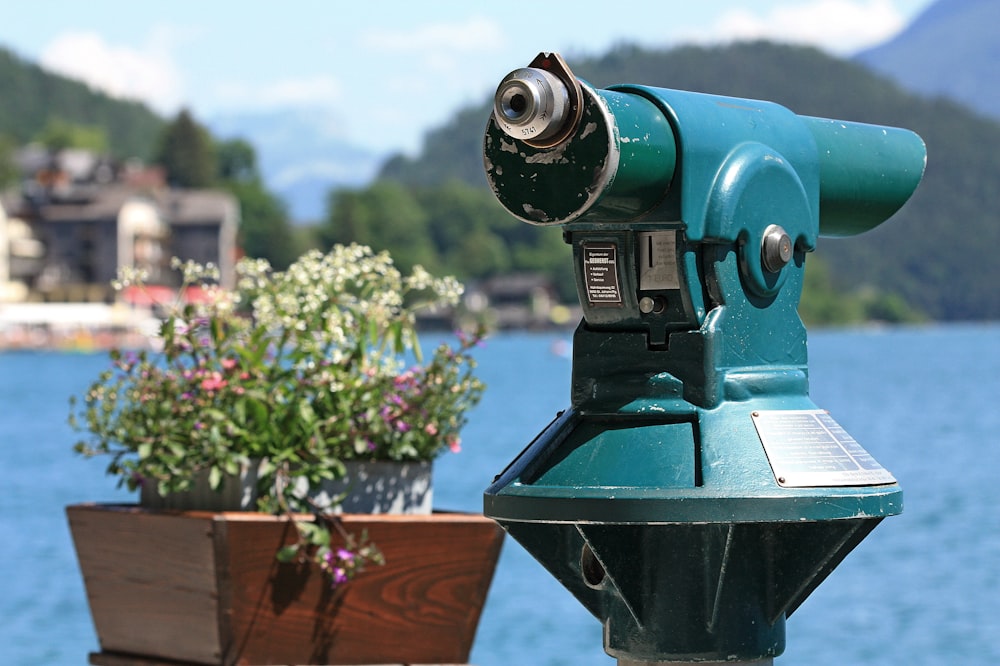 a green and blue telescope sitting on top of a wooden table