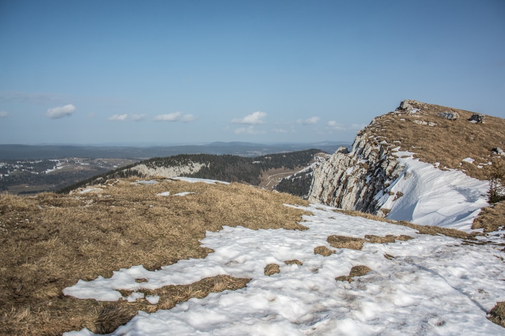 a snow covered hill with a mountain in the background