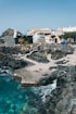 a view of a rocky beach with houses in the background