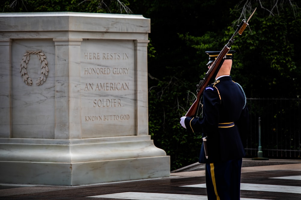 a man in uniform standing in front of a monument