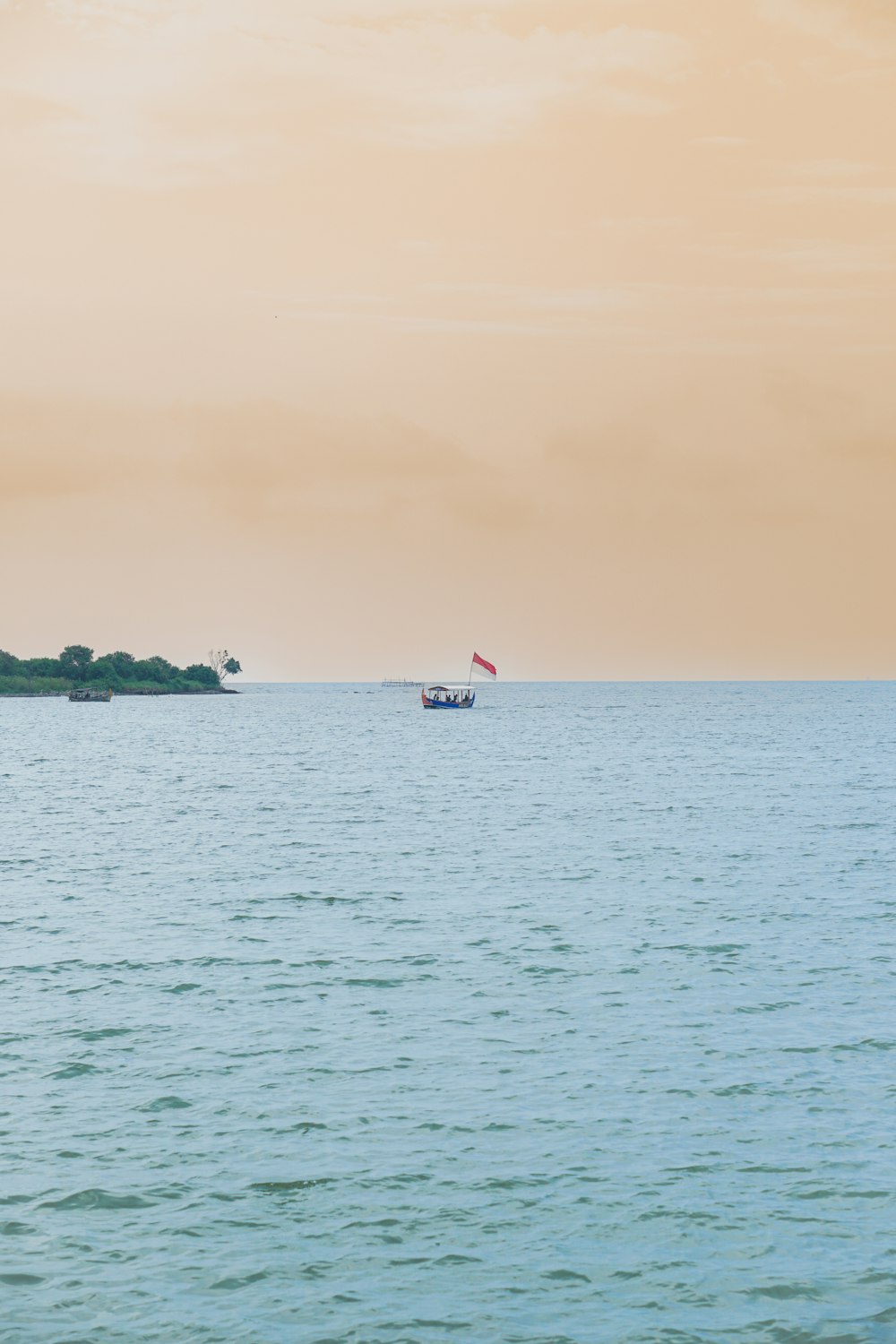 a large body of water with a boat in the distance