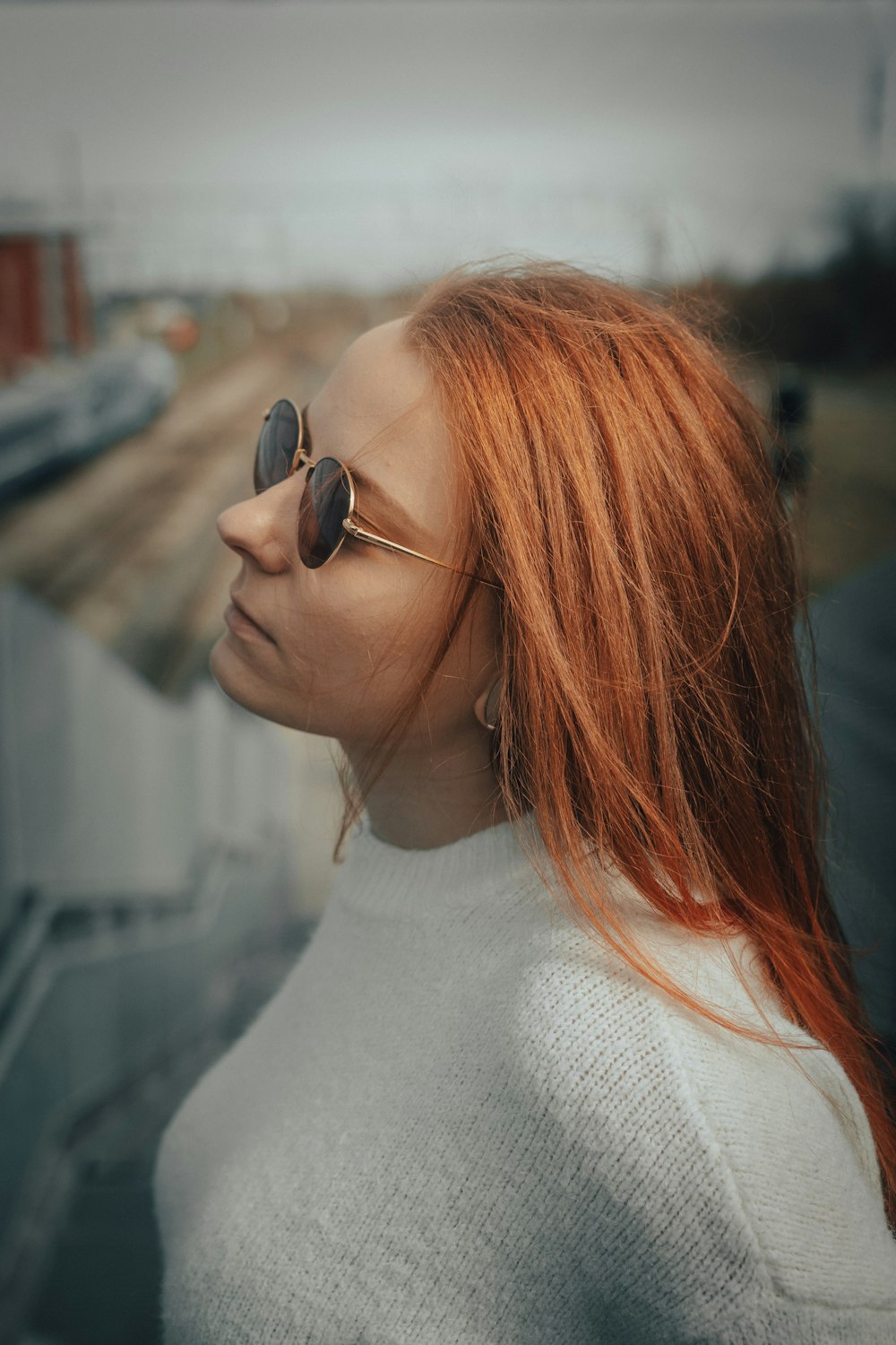 a woman with long red hair wearing sunglasses