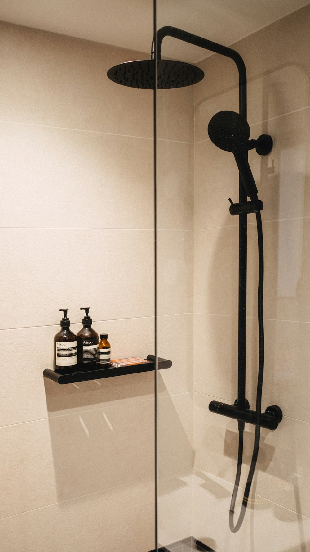 una doccia con soffione nero e rubinetto doccia