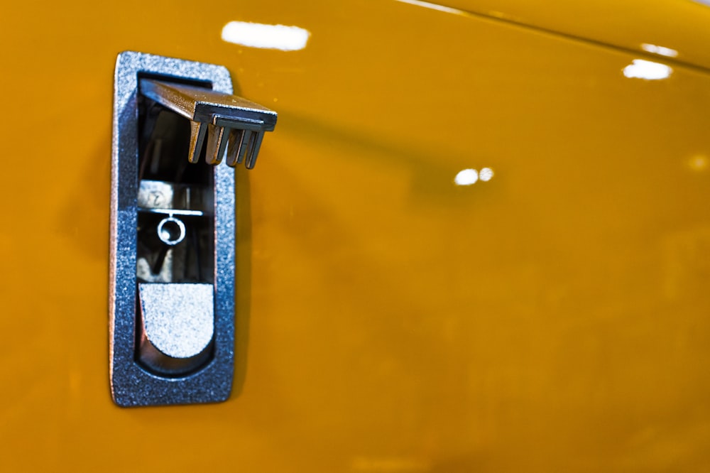 a close up of a door handle on a yellow vehicle