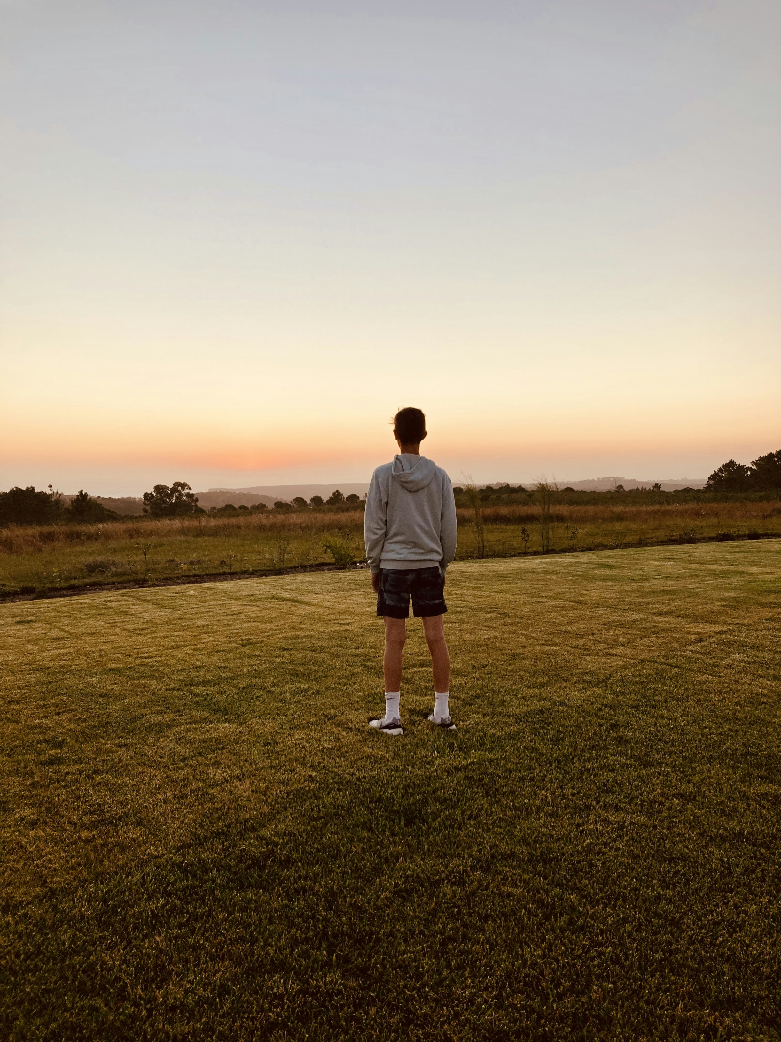 a man standing on top of a lush green field