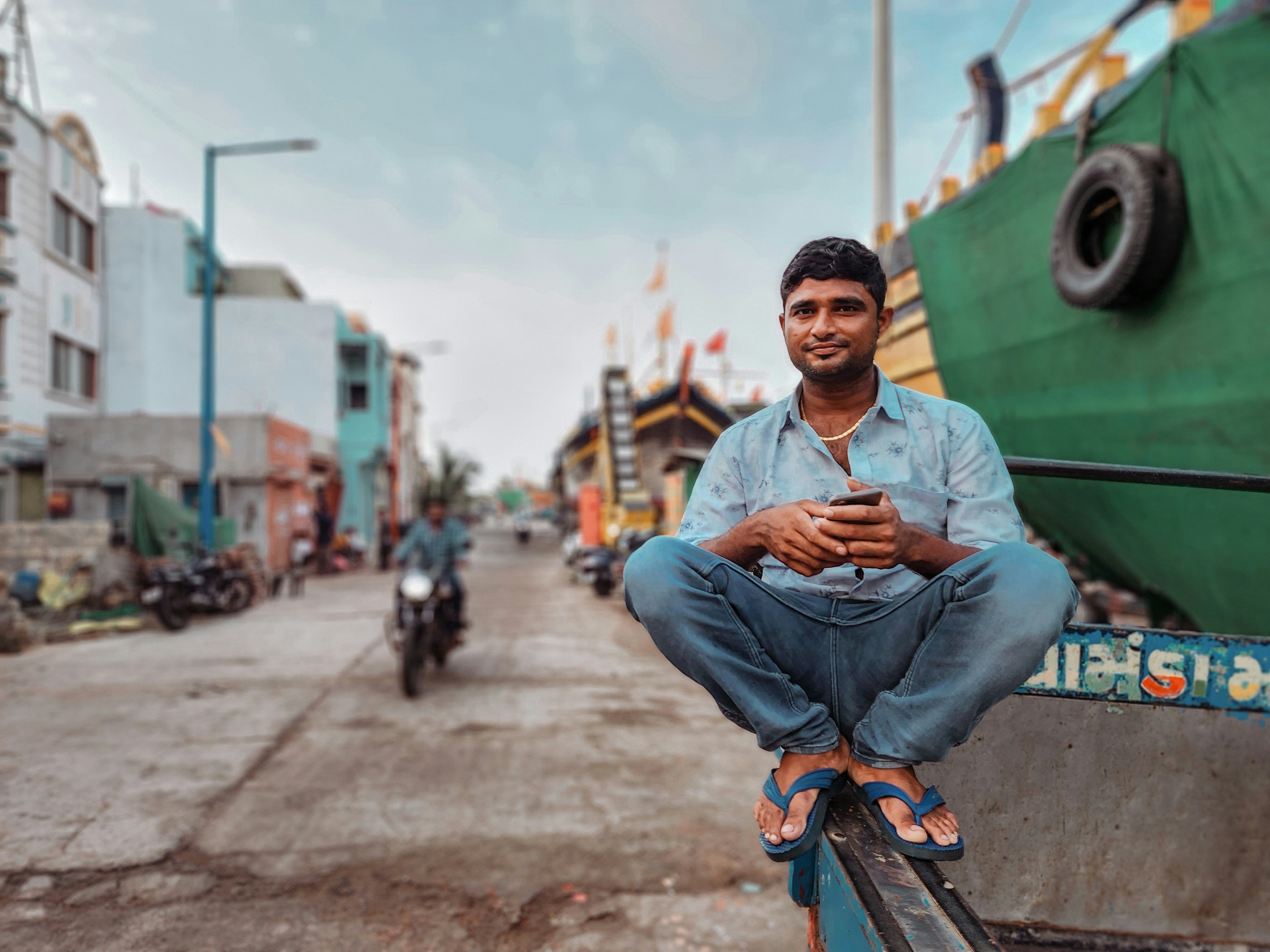 a man sitting on a boat looking at his cell phone