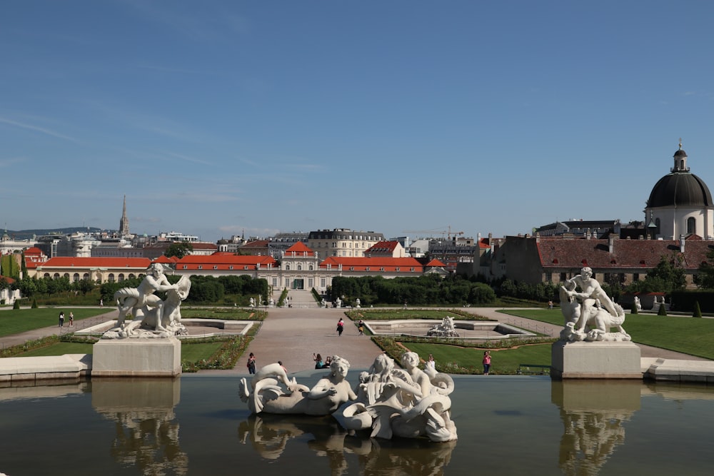 a view of a park with statues and buildings in the background