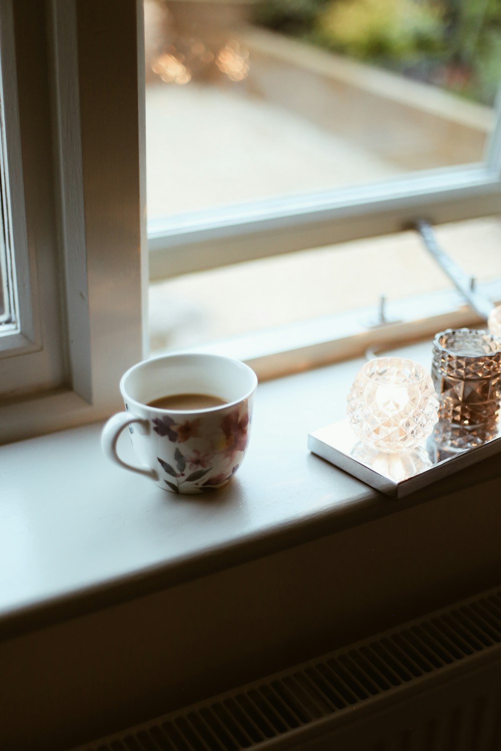 a cup of coffee sitting on top of a window sill