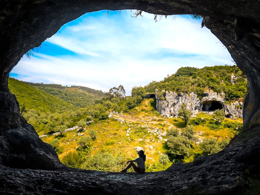 a person sitting in a cave