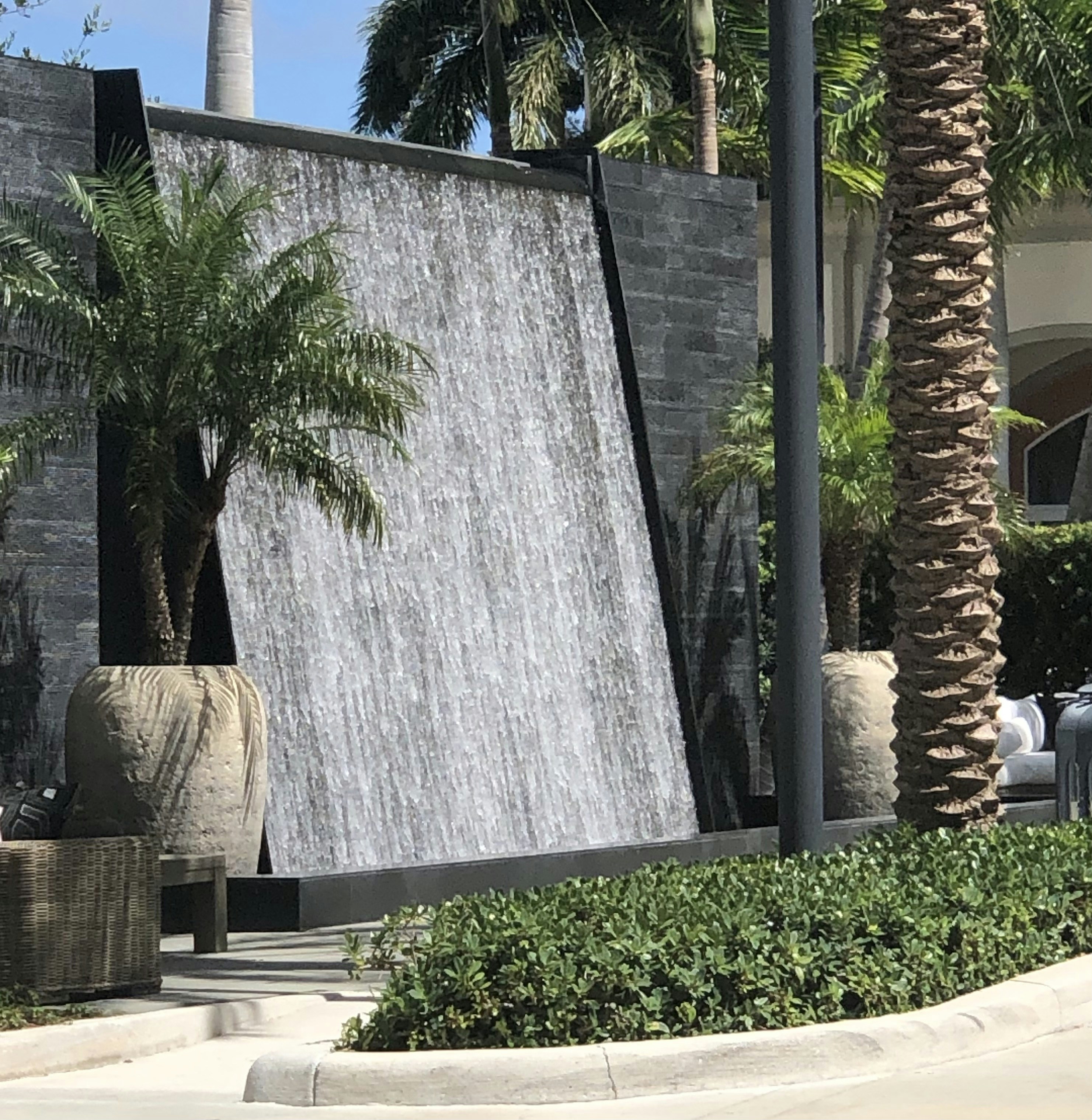 Grand water fountain as focal centerpiece of a luxury estate — warm golden grading