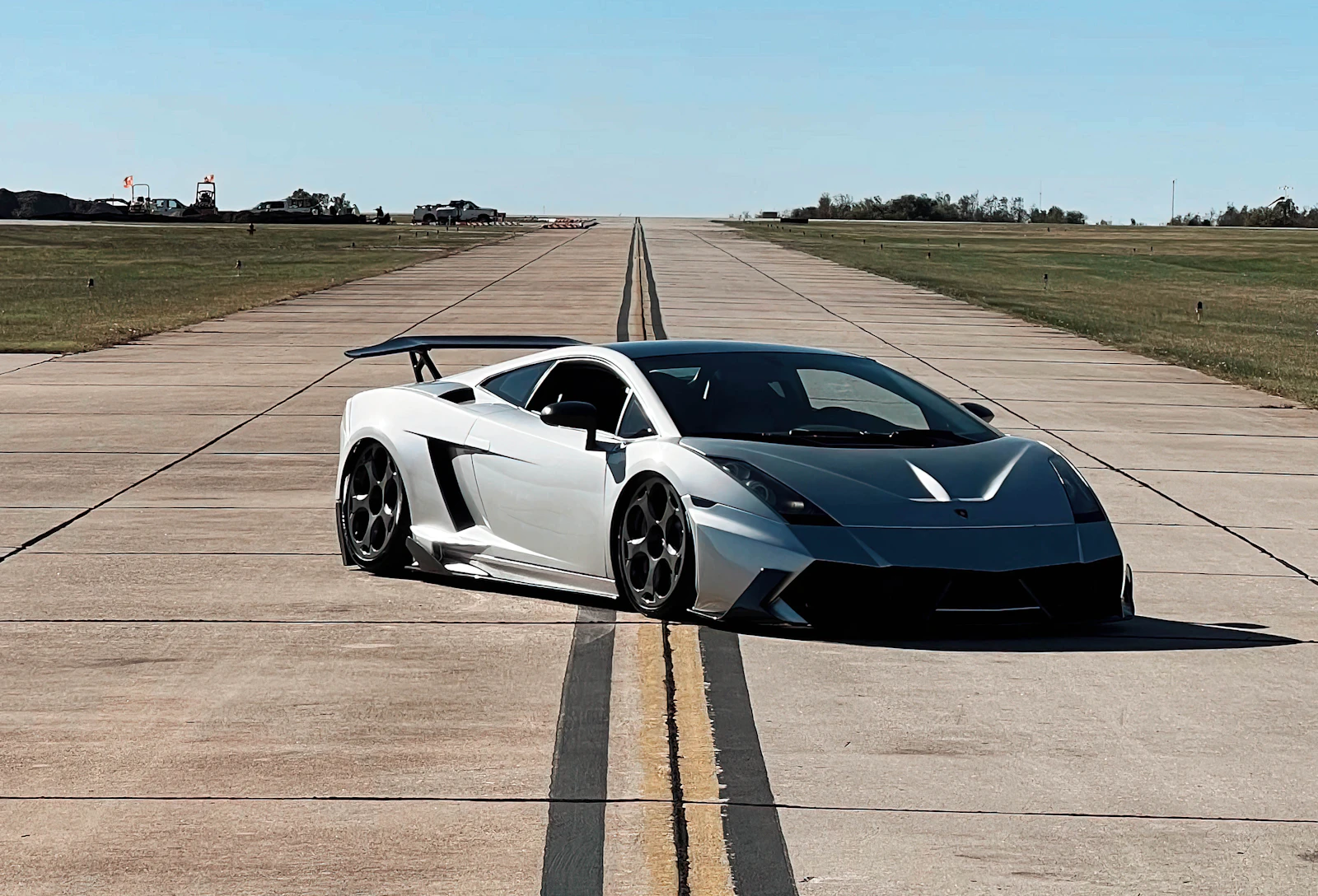 Silver Lamborghini Gallardo with a rear wing on an airfield runway