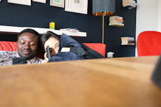 A cozy living room scene with two neighbors chatting on their smartphones.