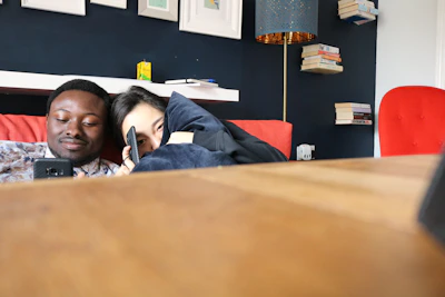 A cozy living room scene with two neighbors chatting on their smartphones.