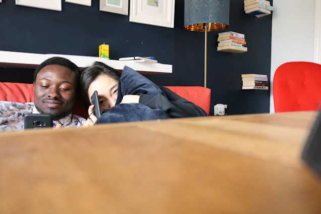 A friendly doctor chatting with a patient over a smartphone in a cozy home setting.