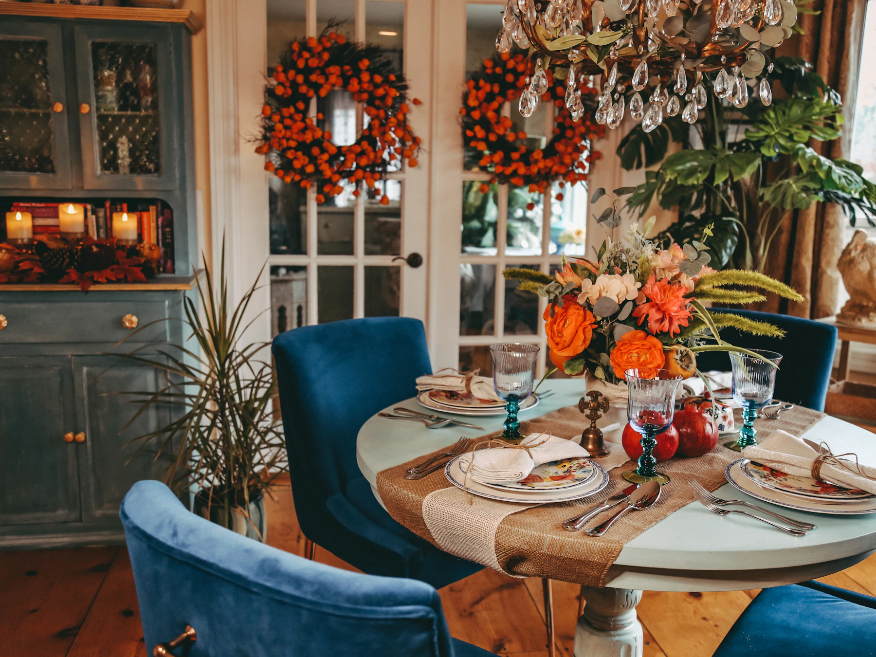 Autumn dining room prepared for a holiday gathering with blue chairs and seasonal table detail