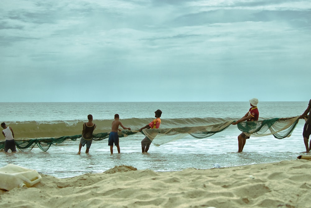 a group of people carrying surfboards on a beach