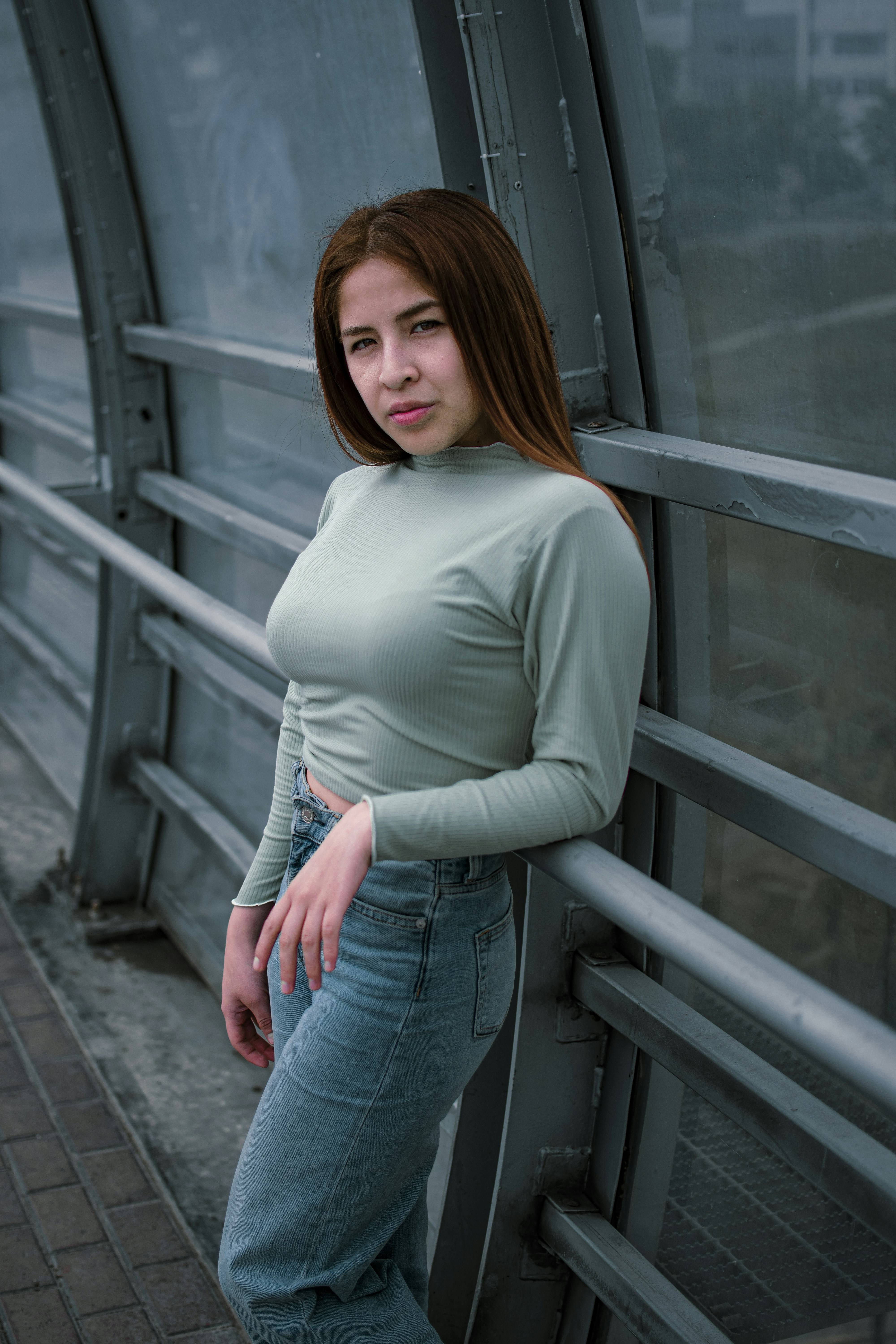 A woman leaning against a railing photo – Free Grey Image on Unsplash