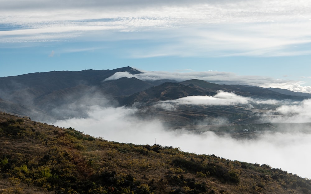 a view of a mountain range with clouds below