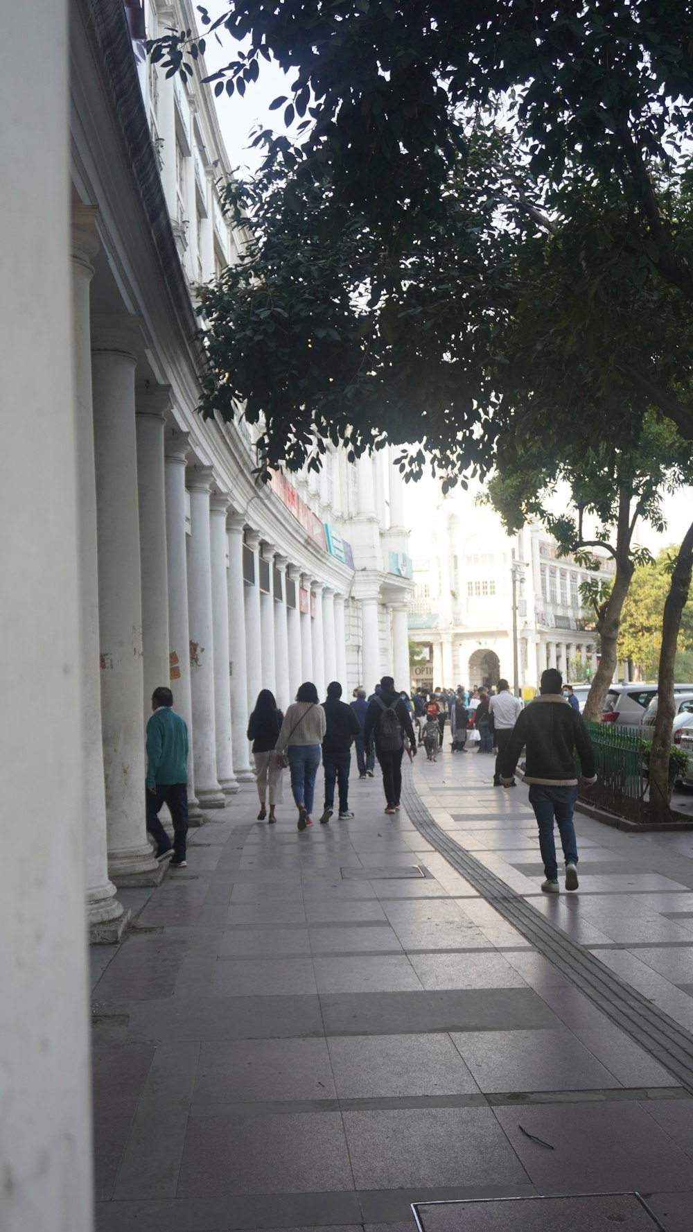 a group of people walking on a sidewalk