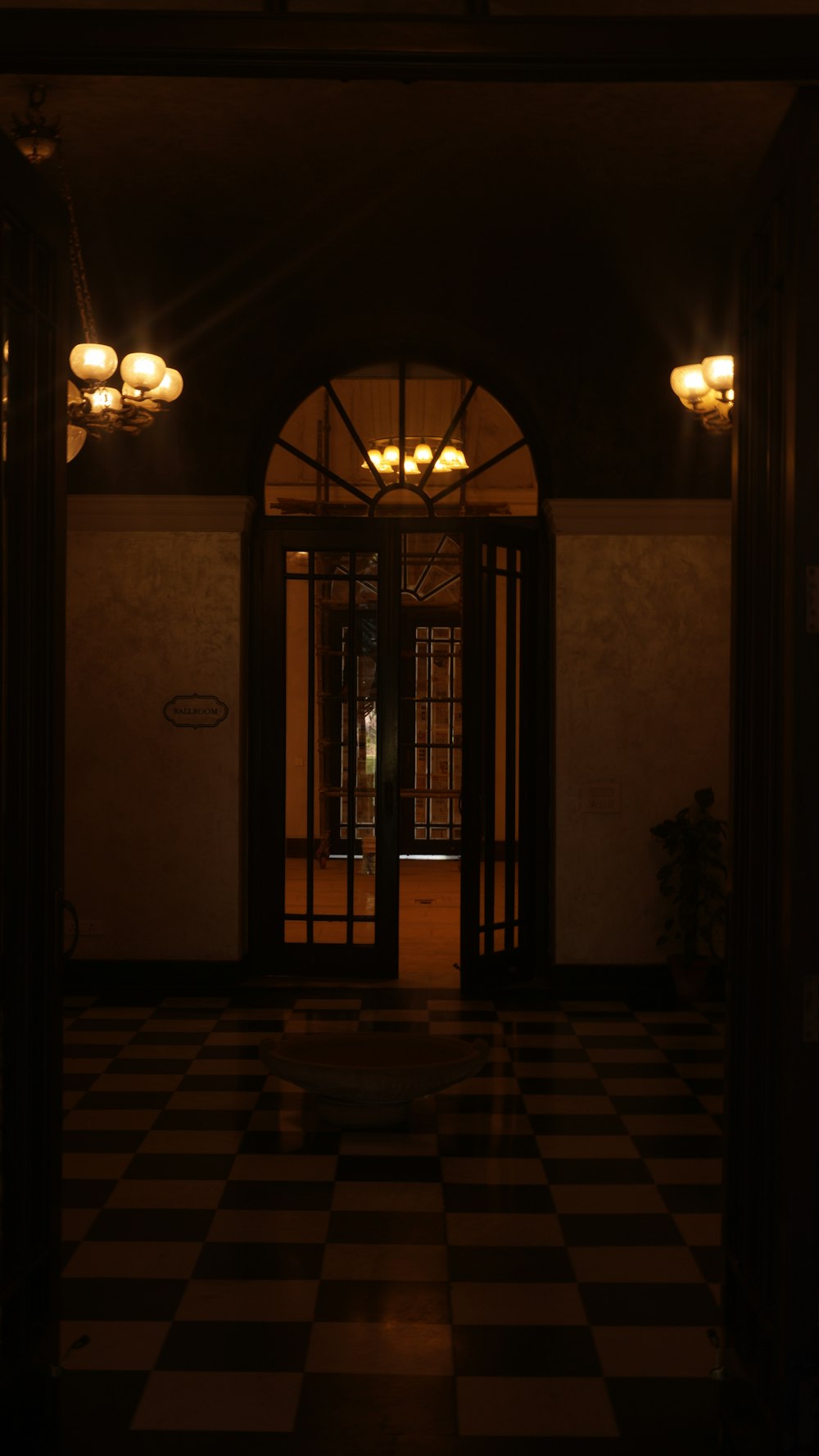 a large black and white checkered floor with a large arched doorway