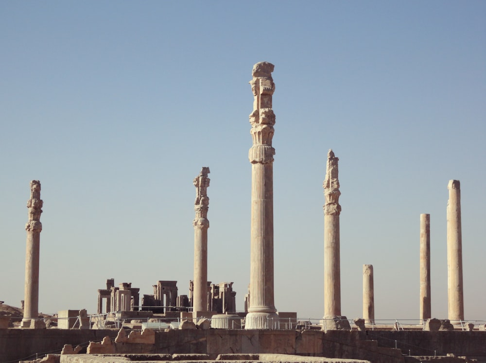 a group of tall pillars with Persepolis in the background