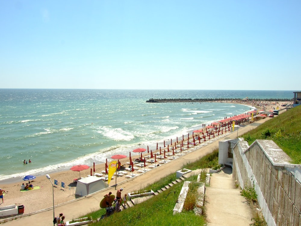 a beach with people and umbrellas