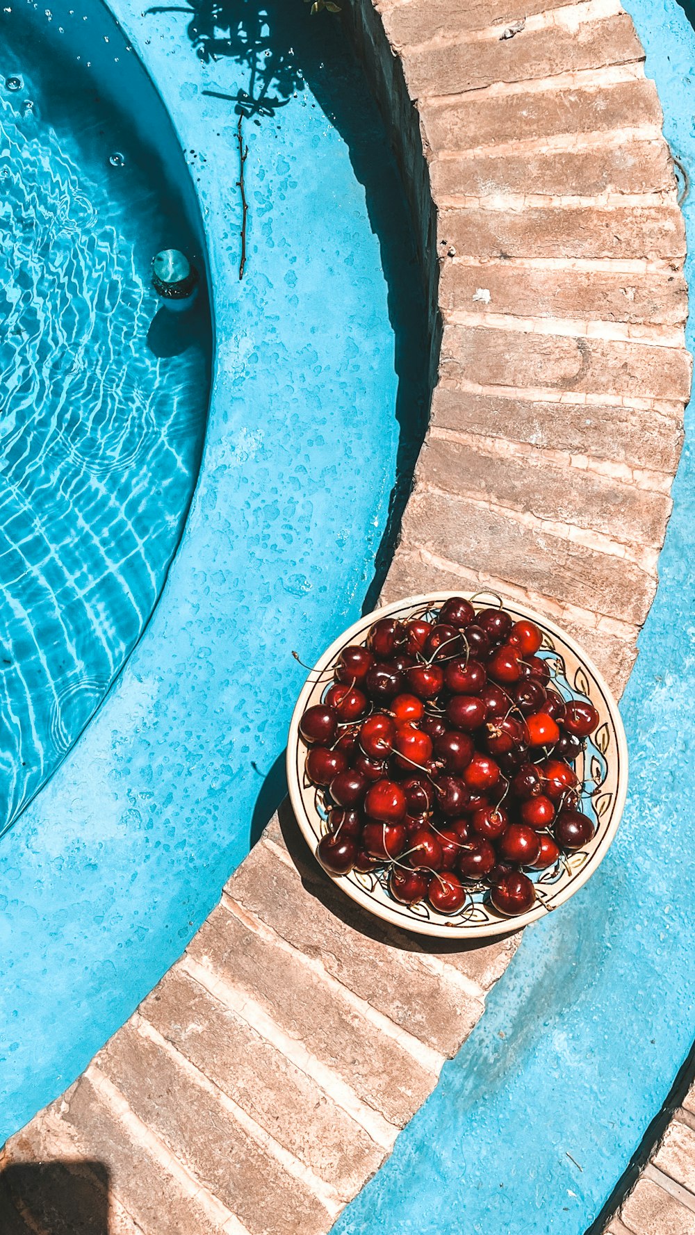 a bowl of berries on a stone surface