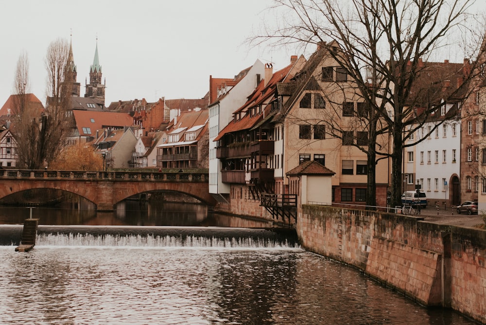 a river with a bridge and buildings along it