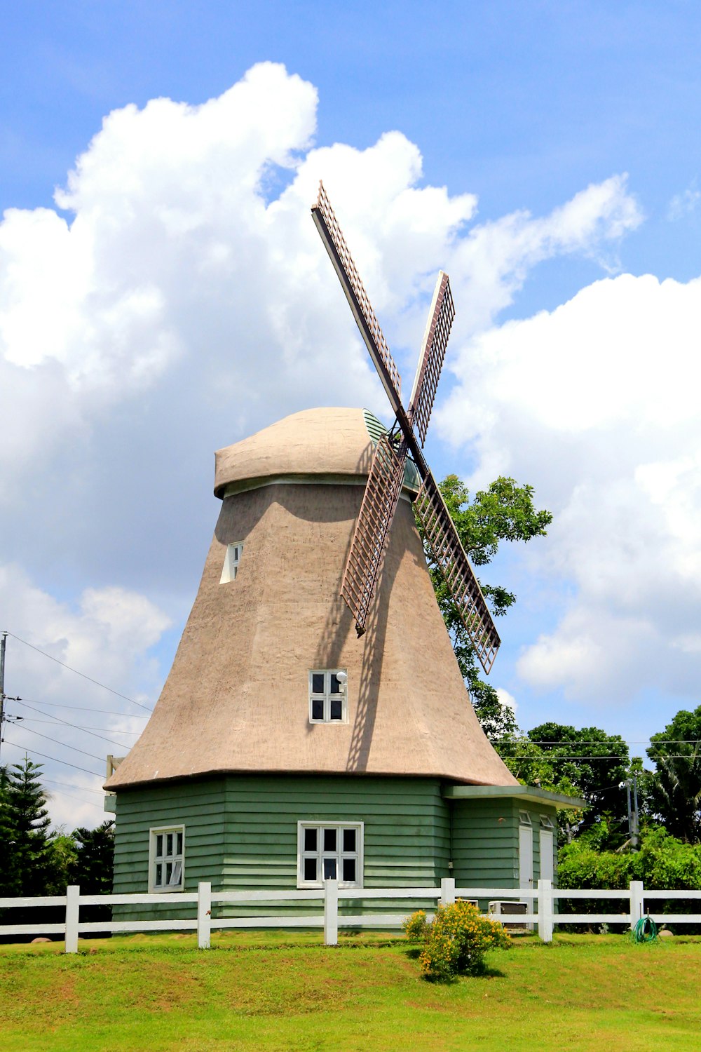 un mulino a vento su una casa con il mulino a vento di Rayleigh sullo sfondo