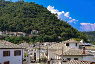 A welcoming community center in Misira village surrounded by lush greenery under a clear blue sky.