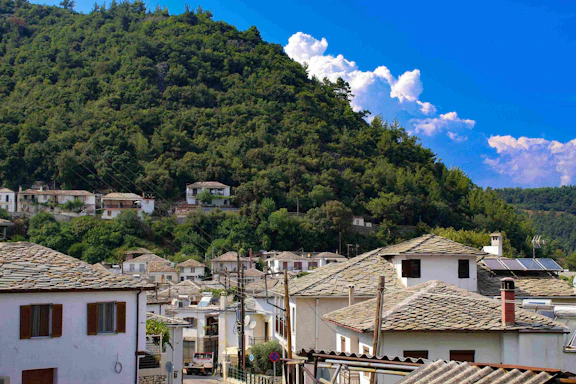 A welcoming community center in Misira village surrounded by lush greenery under a clear blue sky.